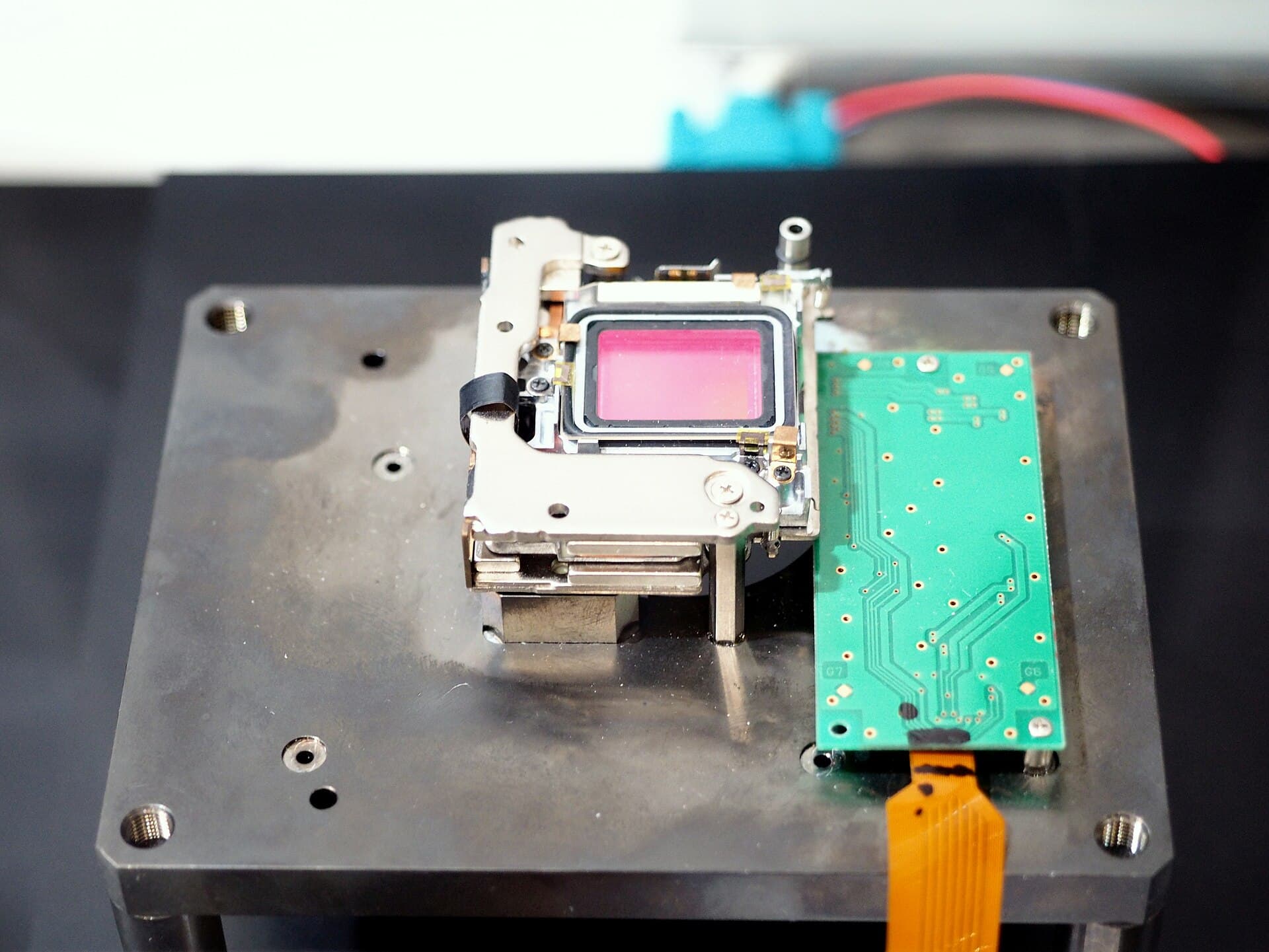 An exposed Olympus mirrorless camera image stabilization unit with its sensor assembly visible