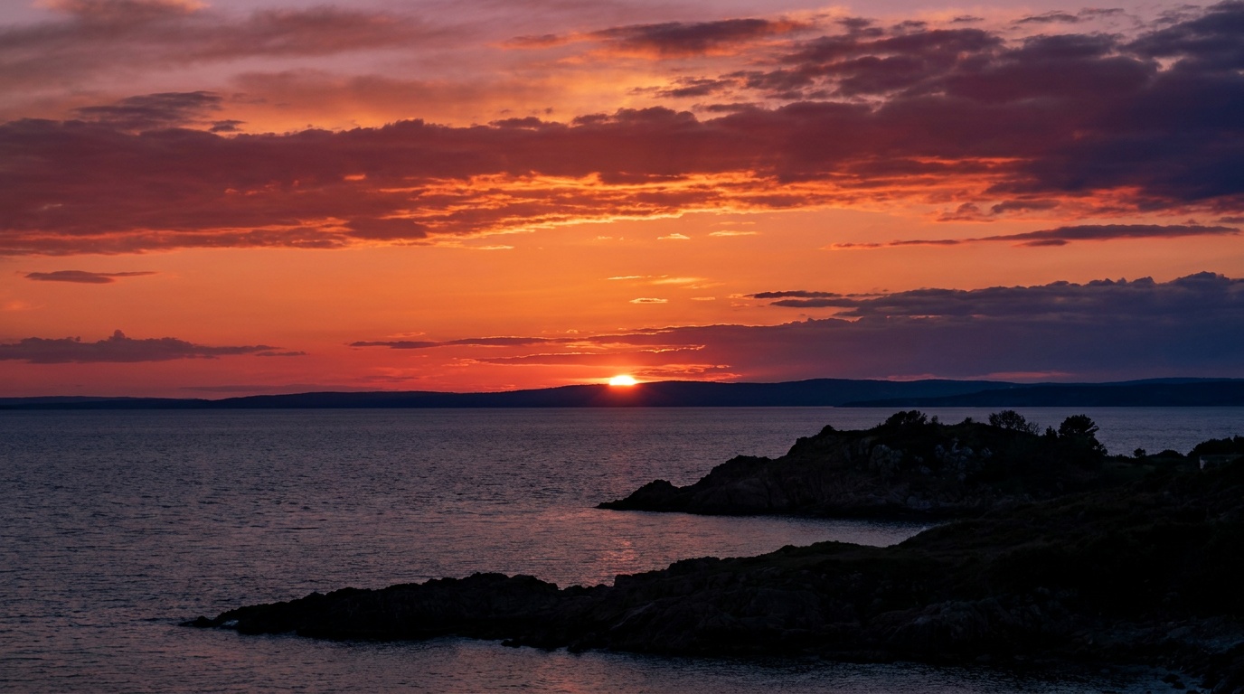 A blazing sunset of deep orange and magenta cloud bands mirrored in glassy still water, the shoreline trees reduced to a crisp black silhouette across the bottom of the frame